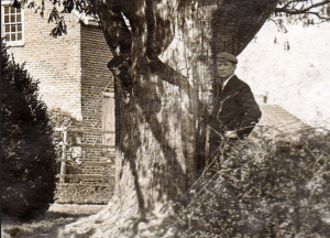 Samuel Rhoads, a relative of Elizabeth Haddon, stands next to a yew tree in front of her house in a 1903 photo. (Rhoads Collection / Historical Society of Haddonfield)