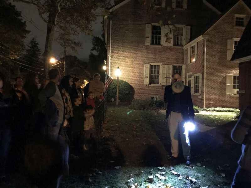 A man speaks to a crowd outside of Greenfield Hall using a megaphone and holding a flashlight
