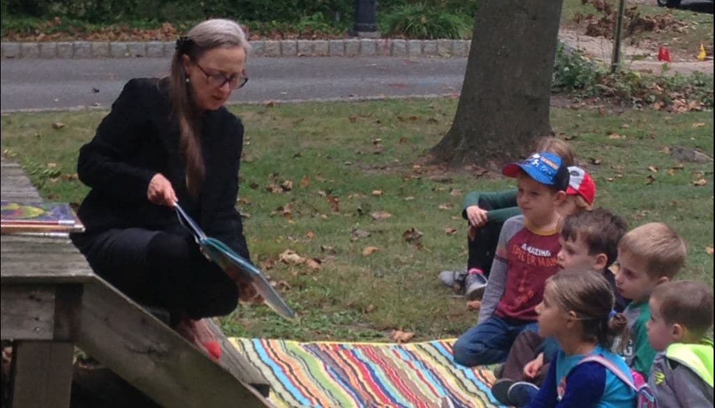 Deborah-story-time-Oct-2019-1024w Woman shows picture book to group of children