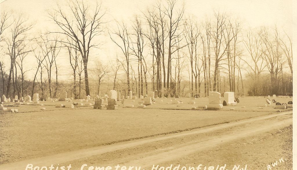Photograph of cemetery headstones and trees