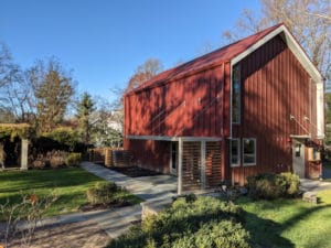 Photograph of the Patricia Lennon Archives Center, a two story building modeled on a historic barn, from the southwest.